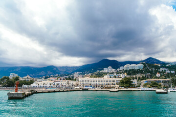 Naklejka premium The seaport of the city of Yalta and the ships, yachts and pleasure boats parked in it, in good sunny weather. Yalta, July, 2018.