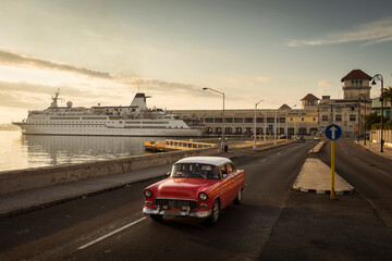 Old car on Malecon street of Havana with sunrise in background. Cuba