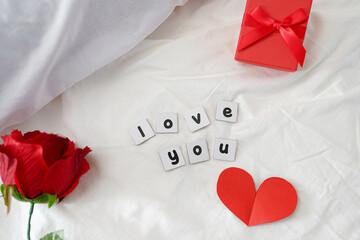 Valentine's day decoration with I love you message on bed with flower and gift box