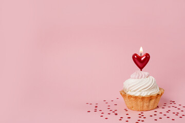 Valentine's day pink background. Vanilla cupcake decorated red heart candle