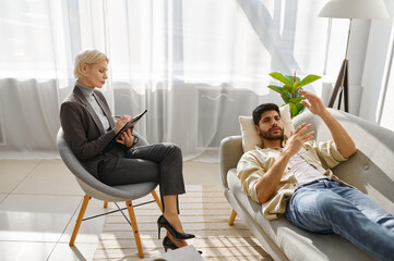 Female psychologist working with man on couch