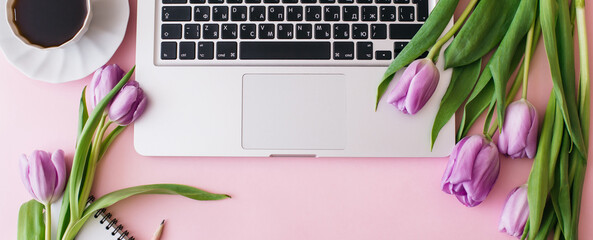 Banner made Workspace with laptop, tulip flowers, cup of coffee on pink background. Home office desk. Flat lay, top view, copy space for text. Spring concept.