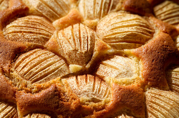 Ein fertig gebackener Apfelkuchen bei dem Zimt über die Äpfel gestreut wurde.
