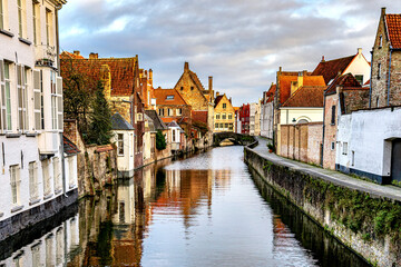 Fototapeta na wymiar View of historical city of Bruges at West Flanders province in Belgium. Inner canals surrounded by old historical buildings. 