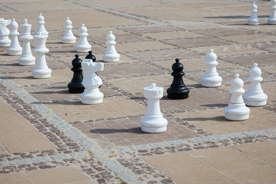 Schachfiguren auf einem Outdoor Schachfeld. Schach das Spiel mit Strategie.
