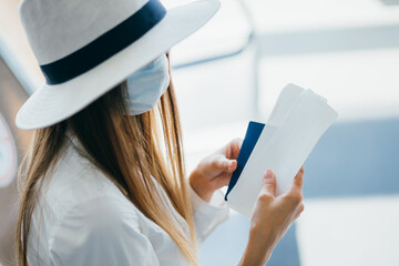 Close-up of a woman hand texting in a messenger or texting on a smartphone at an airport window. Silhouette of hands a woman with a phone. Travel woman using smartphone at airport.