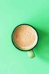 One coffee cup on a green background. Top view.