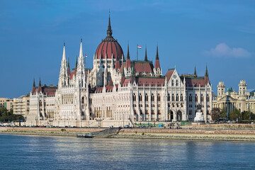 Fototapeta premium Budapest, Hungary. The Hungarian Parliament Building on the bank of the Danube, and fragment of the building of Ethnographic Museum, former Royal Palace of Justice.