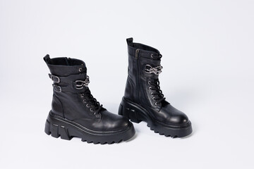 Women's shoes on a white background. Close-up of women's black leather boots with buckles on a white background. Shoes for the city. Concept for 2022 fashion, design and footwear.