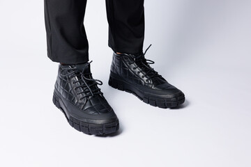 Men's black boots made of genuine leather, men's footwear on a white background. Winter men's shoes 2022