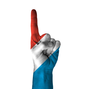 Hand pointing thumb up direction, luxembourg painted with flag as symbol of up direction, first and number one symbol - isolated on white background