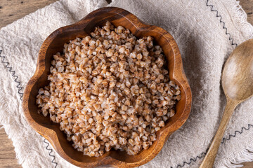 buckwheat in a wooden plate on a wooden background