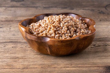 buckwheat in a wooden plate on a wooden background