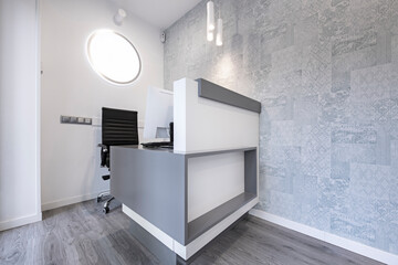 Reception desk with black chair in a commercial space with soft colors