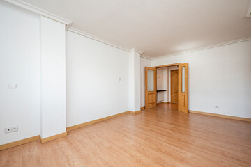 Large empty room with light oak wood floors and doors of the same material