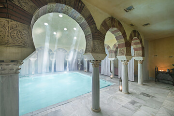 Inner courtyard with covered thermal water pool and twin arches - obrazy, fototapety, plakaty