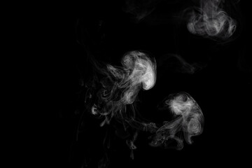 Beautiful abstract cloud of smoke isolated on black background. White smoke glow in the dark, steam gushing to form free shapes.