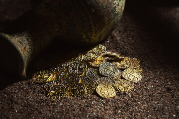 Old treasure in the sand. Treasure discovering concept. Jug with gold coins. Selective focus.