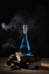  Bottle of magic potion, witchery herbs and books of spells or recipes on the wizard's desk...