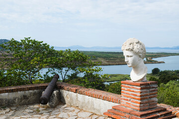 Bust (statue) of the goddess Butrint against the background of the sky and the Ionian Sea. Butrint, Albania.