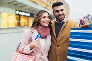 Young happy couple after shopping holding a credit card