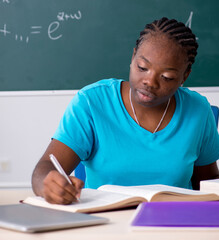 The black female student in front of chalkboard