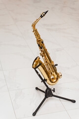 Saxophone musician instrument on stand on white background. Sax musical instrument for play jazz.