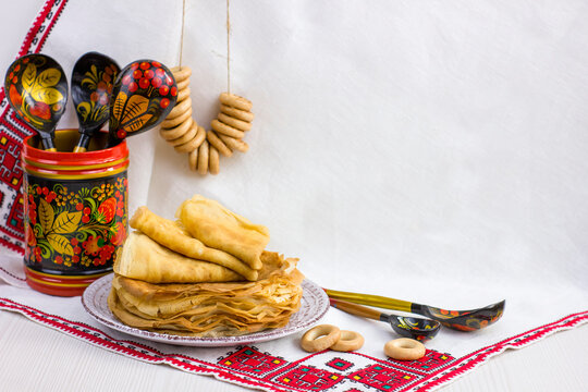 Background with pancakes, wooden utensils with Khokhloma painting, rushnik and sushki for Maslenitsa festival.