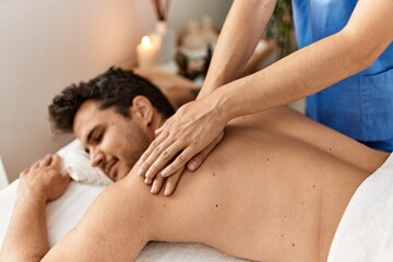 Obraz na płótnie Canvas Man smiling happy reciving back massage at beauty center.