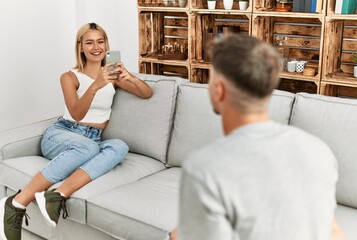 Woman making photo to her boyfriend using smartphone at home.