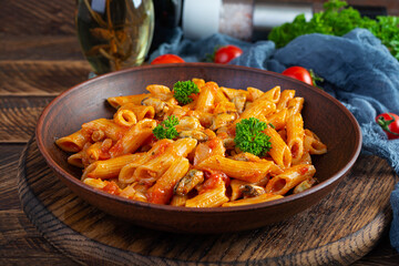 Pasta penne in marinara sauce with mussels, onion and parsley. Classic Italian pasta penne