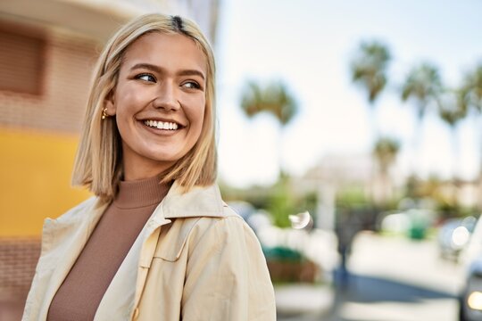 Young blonde girl smiling happy standing at the city.