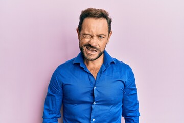 Middle age man wearing casual clothes winking looking at the camera with sexy expression, cheerful and happy face.