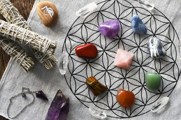 A top view image of chakra healing crystals arranged on sacred geometry grid cloth with rose quartz...
