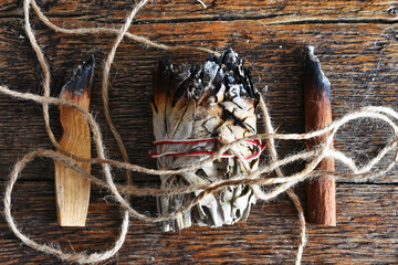 A top view image of three different smudge sticks on a wooden table top. 