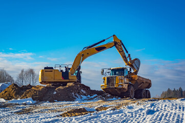 excavator load Articulated dump truck at snow - obrazy, fototapety, plakaty