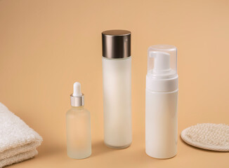bottles with cosmetic foam or gel on beige background, selective focus. Mockup for branding and packaging presentation. beauty and spa concept