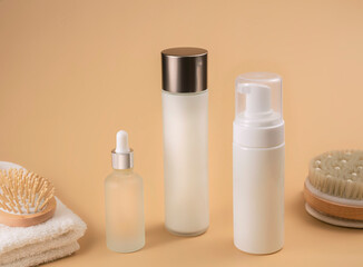 bottles with cosmetic foam or gel on beige background, selective focus. Mockup for branding and packaging presentation. beauty and spa concept
