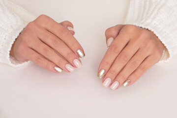 Obraz na płótnie Canvas Beautiful female hands with beige and golden manicure nails on white background