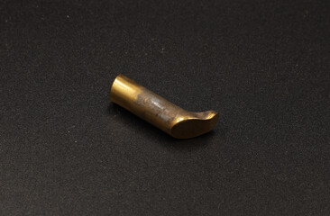 golden spare parts for a pistol on a black background