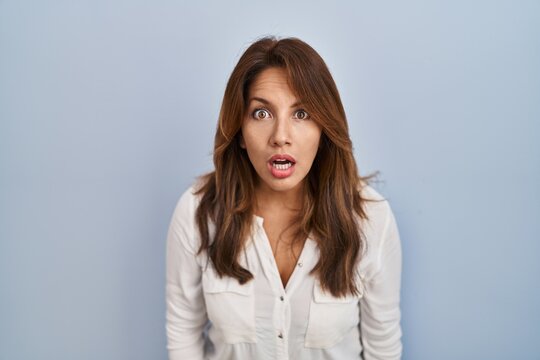 Hispanic woman standing over isolated background afraid and shocked with surprise and amazed expression, fear and excited face.
