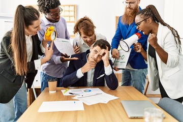 Group of business workers screaming to stressed partner at the office.