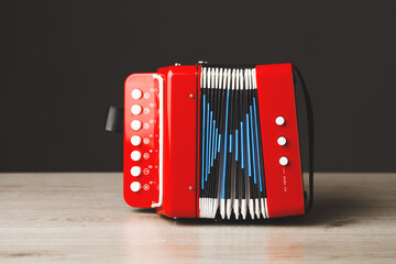 red bayan toy accordion on gray background