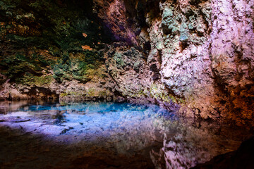 Stalactites and stalagmites in a Kuza cave at Zanzibar, Tanzania. Natural pool with crystal clear...
