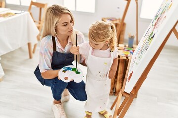 Mother and daughter smiling confident drawing at art studio