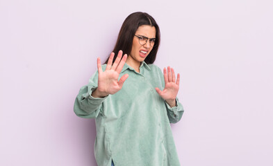 pretty young woman feeling terrified, backing off and screaming in horror and panic, reacting to a...