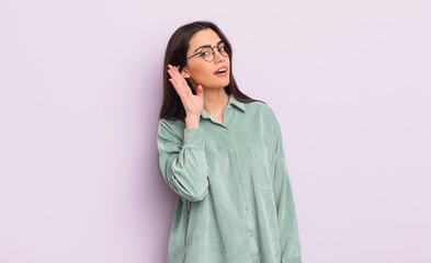 pretty young woman looking serious and curious, listening, trying to hear a secret conversation or...