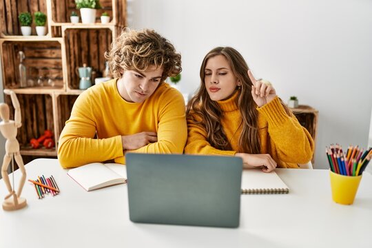 Young caucasian couple having online art class at home