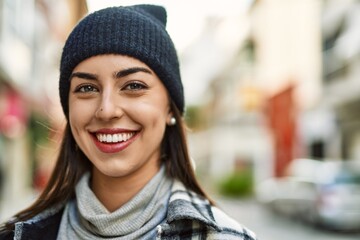 Young hispanic woman smiling happy standing at the city.