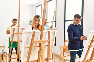 Group of middle age paint students drawing at art studio.